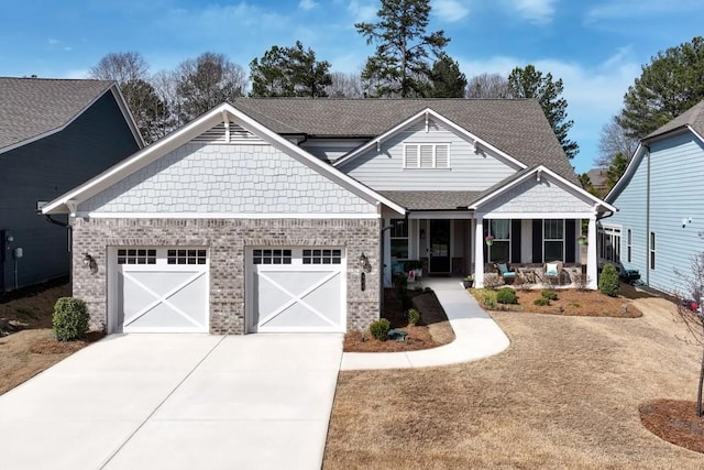 craftsman-style home with a porch, roof with shingles, concrete driveway, an attached garage, and brick siding