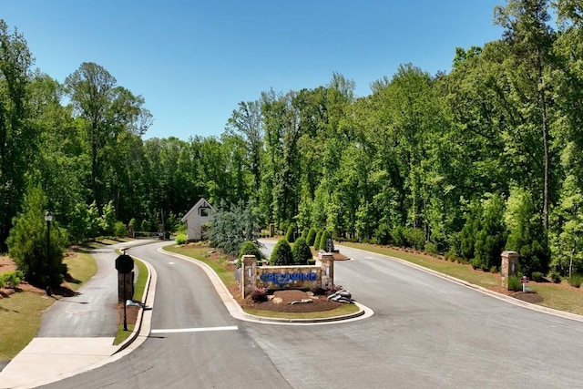 view of road with curbs and a gated entry