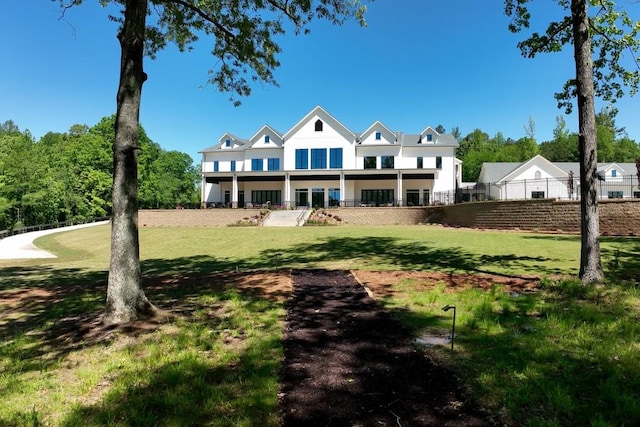 back of house with a yard, a balcony, and fence