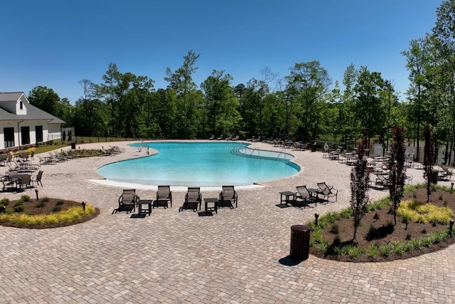 community pool featuring a patio area and fence