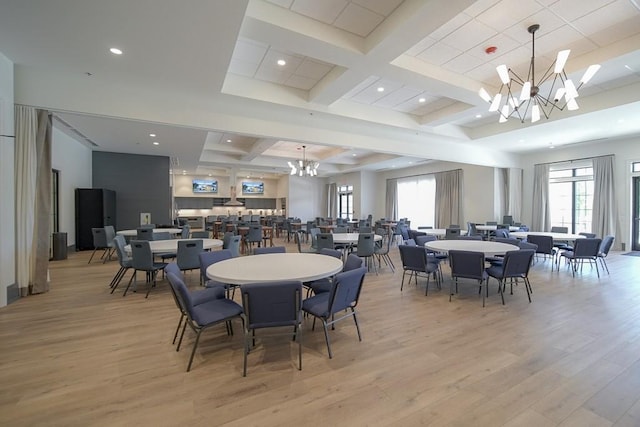 dining space with light wood finished floors, a notable chandelier, and beam ceiling