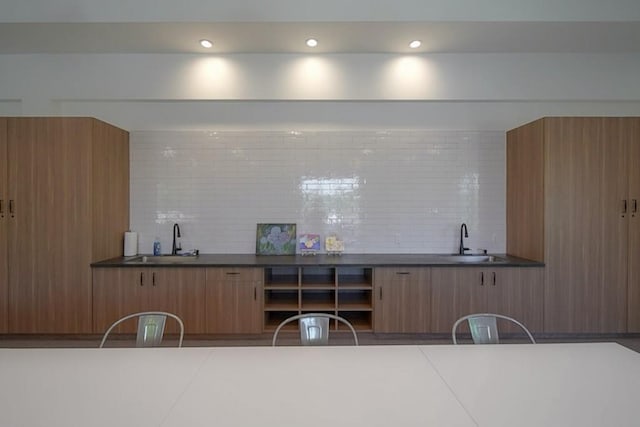 bar with recessed lighting, backsplash, and a sink