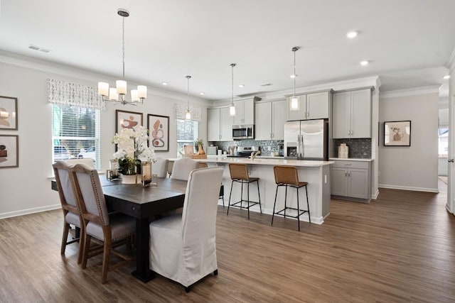 dining area featuring an inviting chandelier, plenty of natural light, and dark wood-type flooring