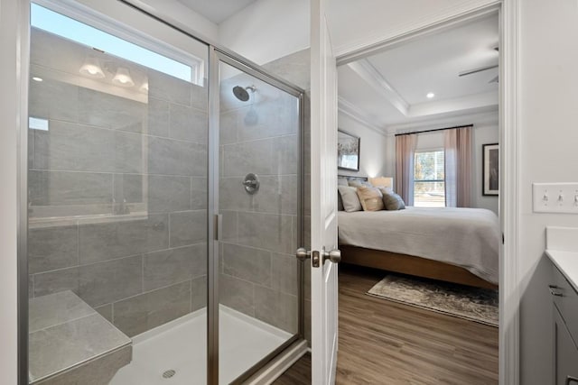 bathroom with vanity, a raised ceiling, crown molding, an enclosed shower, and wood-type flooring