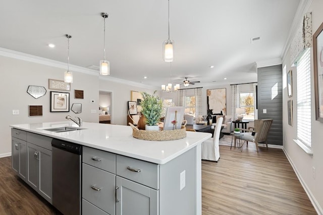 kitchen with ceiling fan, dishwasher, sink, pendant lighting, and a kitchen island with sink