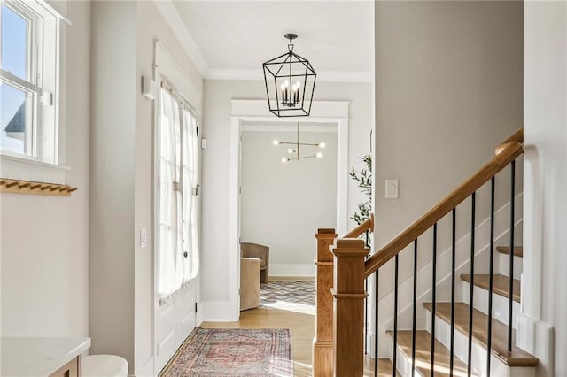 entryway featuring crown molding, hardwood / wood-style floors, and a chandelier