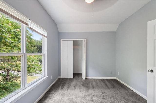 unfurnished bedroom featuring ceiling fan, vaulted ceiling, and carpet flooring