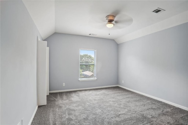 carpeted spare room featuring ceiling fan and lofted ceiling