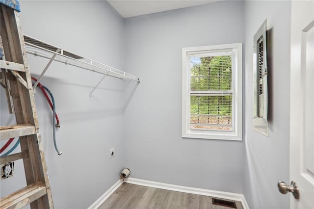 clothes washing area with hardwood / wood-style floors and electric dryer hookup