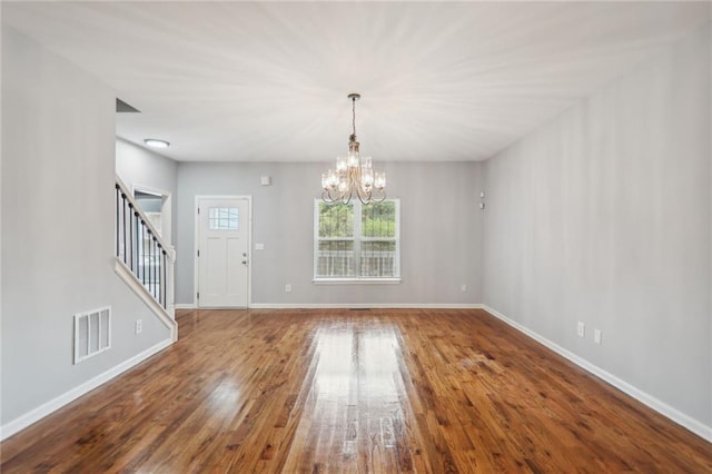 interior space featuring wood-type flooring and an inviting chandelier