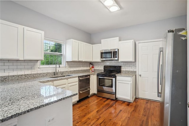 kitchen featuring white cabinets, stainless steel appliances, sink, dark hardwood / wood-style floors, and light stone counters