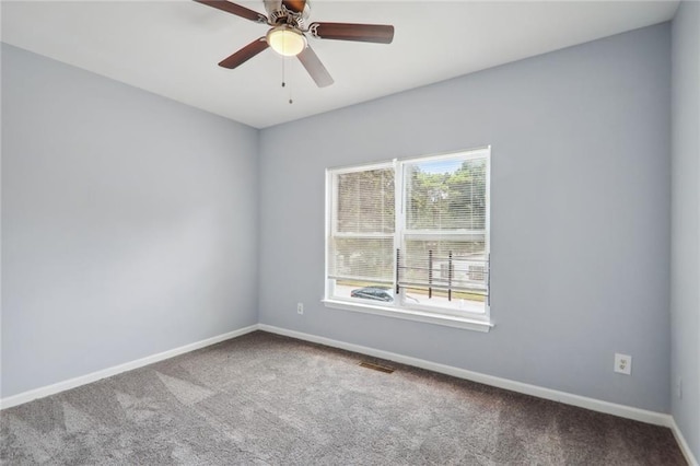 empty room featuring ceiling fan and carpet