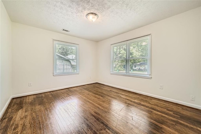 unfurnished room with dark hardwood / wood-style flooring and a textured ceiling