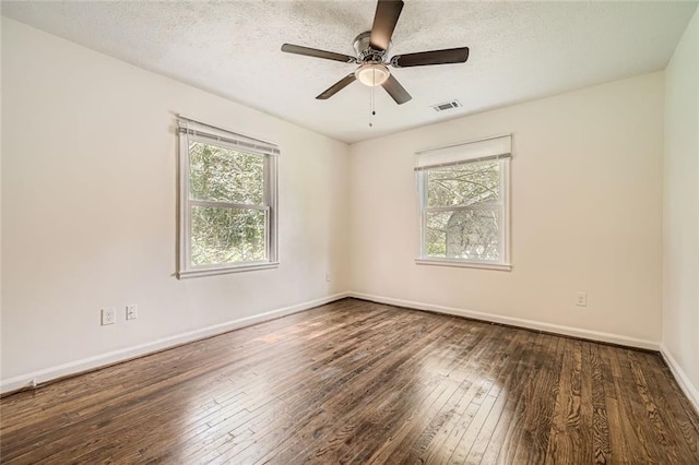 unfurnished room featuring a wealth of natural light, dark hardwood / wood-style flooring, and ceiling fan