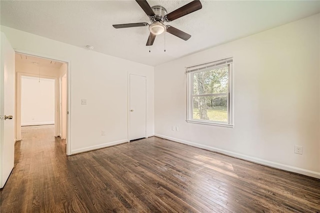 unfurnished bedroom featuring ceiling fan, dark wood-type flooring, and a closet