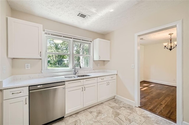 kitchen featuring stainless steel dishwasher, white cabinets, sink, and a textured ceiling