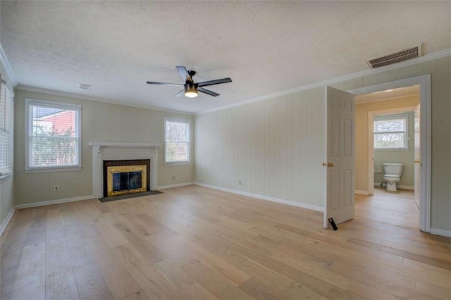 4131 Carroll St, Covington, GA 30014 - unfurnished living room with crown molding, light wood finished floors, ceiling fan, a textured ceiling, and a fireplace with flush hearth