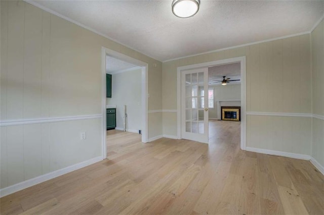 4131 Carroll St, Covington, GA 30014 - unfurnished room with light wood-type flooring, a fireplace, crown molding, a ceiling fan, and a textured ceiling