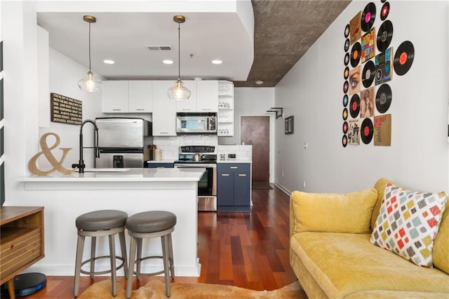 3324 Peachtree Rd NE Unit 1813, Atlanta, GA 30305 - kitchen with stainless steel appliances, a sink, light countertops, dark wood finished floors, and a peninsula