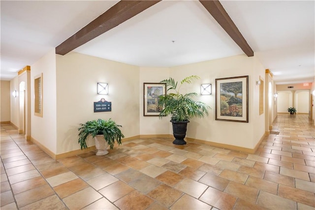 hall with beam ceiling and baseboards