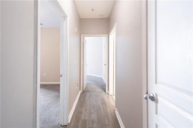 hallway with wood finished floors and baseboards