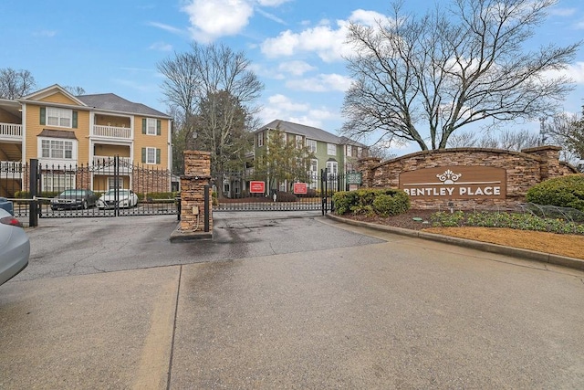 view of road featuring a gated entry and curbs