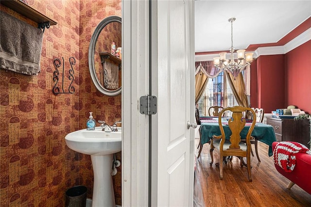 bathroom with hardwood / wood-style floors, a chandelier, and ornamental molding