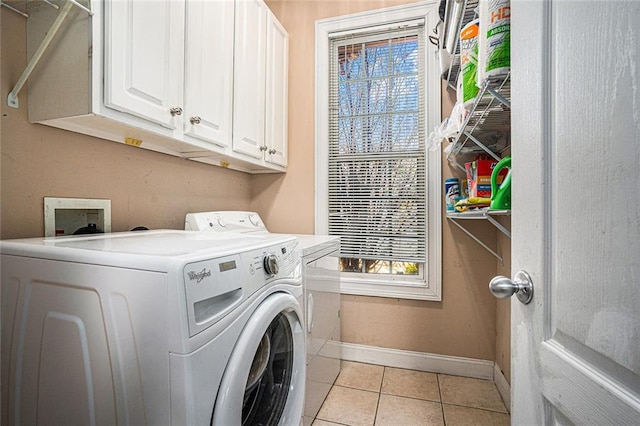 clothes washing area with light tile patterned flooring, cabinets, and independent washer and dryer