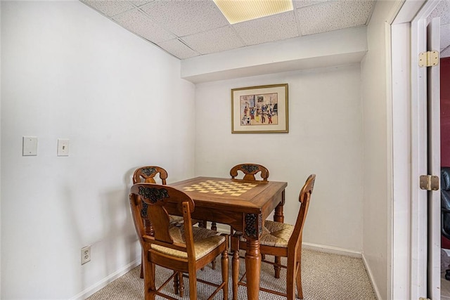 carpeted dining room with a drop ceiling