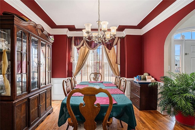 dining room featuring crown molding, light hardwood / wood-style floors, and a notable chandelier