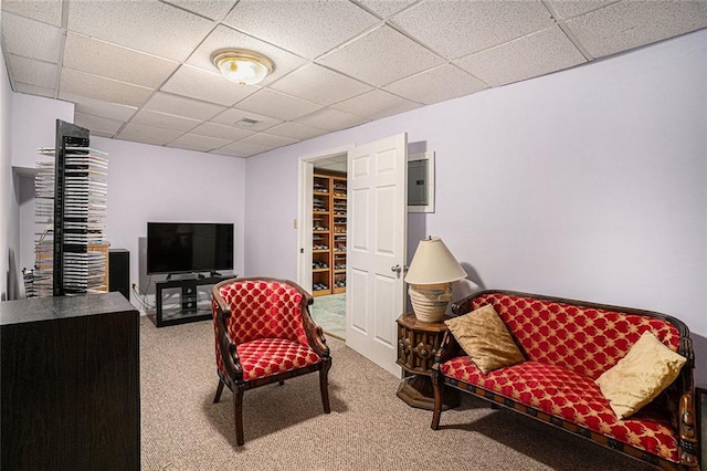 carpeted living room with a drop ceiling