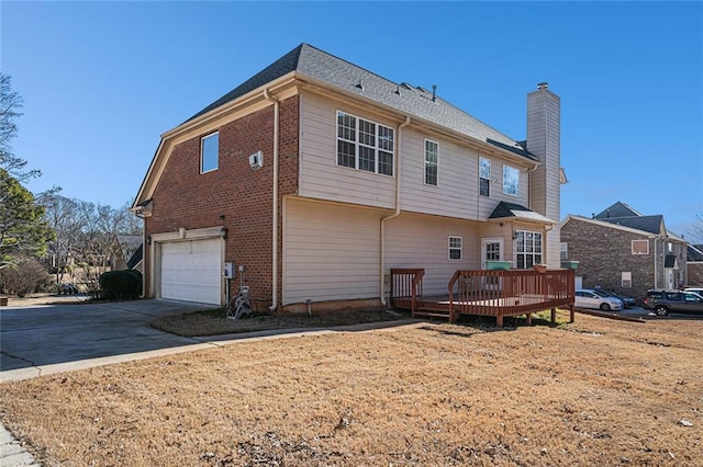 rear view of house featuring a deck and a garage