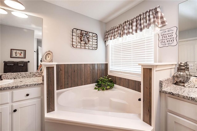full bathroom with a bath and vanity