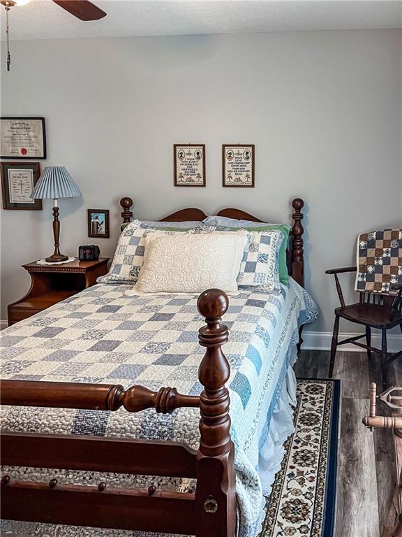 bedroom with wood finished floors, baseboards, and ceiling fan