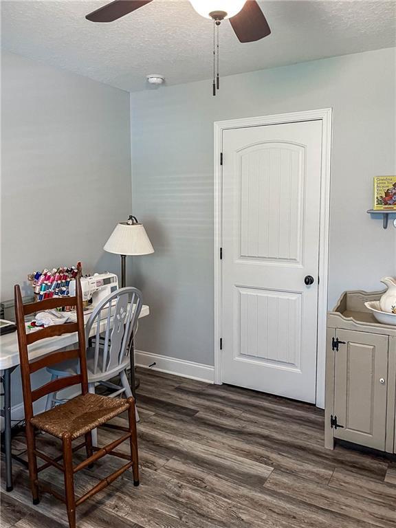 office area with dark wood-style flooring, a ceiling fan, and a textured ceiling