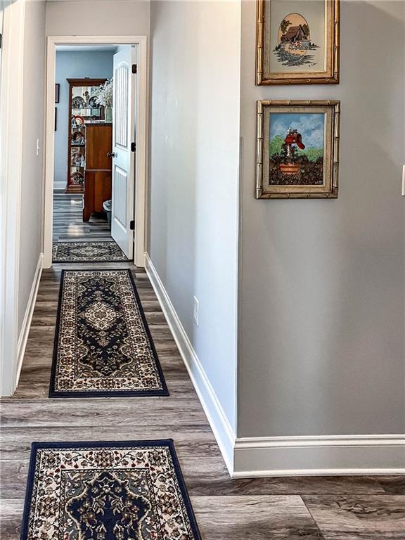 hall featuring baseboards and dark wood finished floors