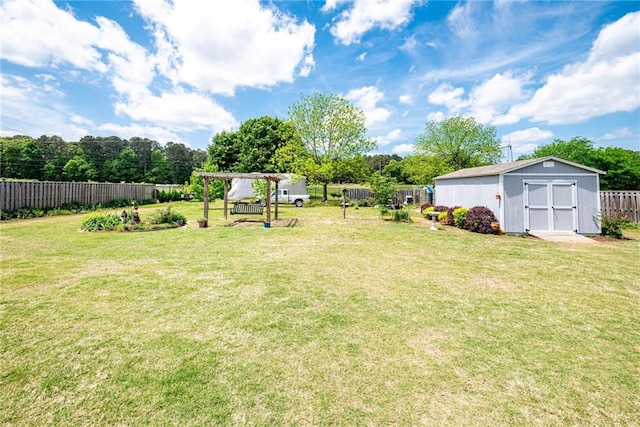 view of yard with fence, an outdoor structure, and a storage shed
