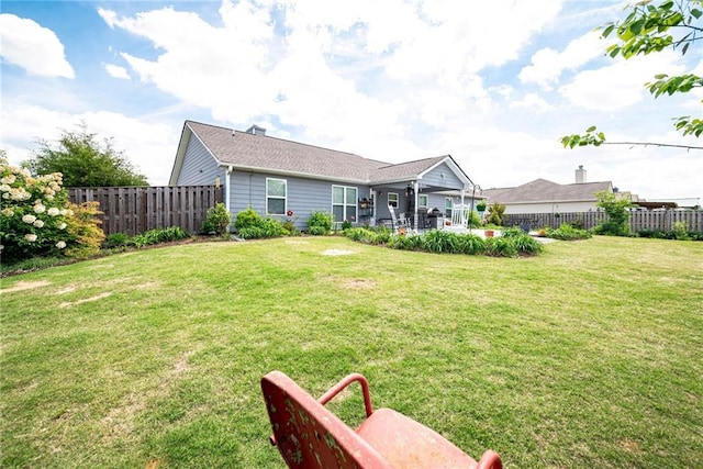 back of house featuring a patio area, a lawn, and a fenced backyard