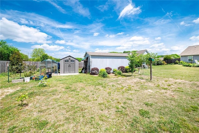 view of yard featuring an exterior structure, an outdoor structure, fence, and a storage shed