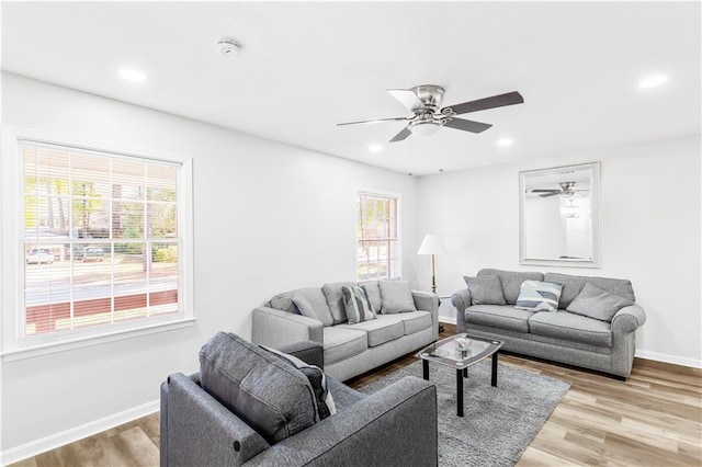 living room featuring ceiling fan and light hardwood / wood-style flooring