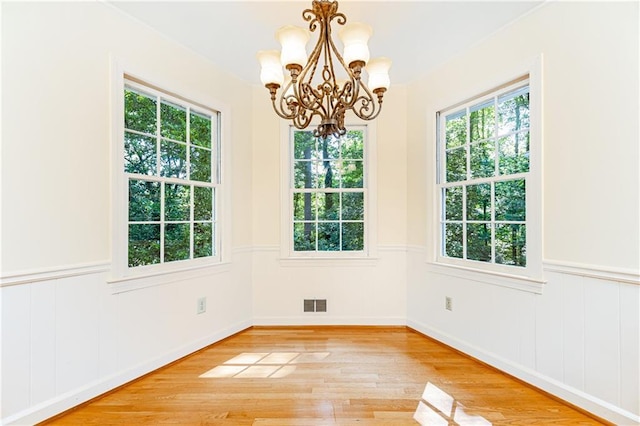 5287 Vernon Lake Dr, Atlanta, GA 30338 - unfurnished dining area featuring a chandelier, healthy amount of natural light, a wainscoted wall, and light wood-style flooring