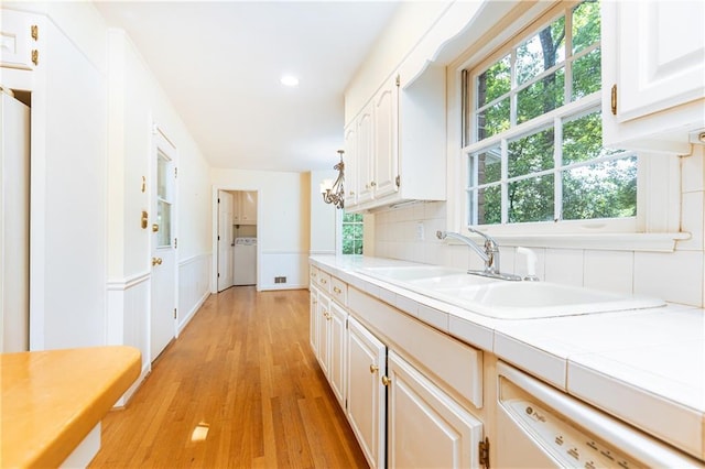 5287 Vernon Lake Dr, Atlanta, GA 30338 - kitchen with washer / dryer, a sink, tile countertops, white cabinetry, and light wood finished floors