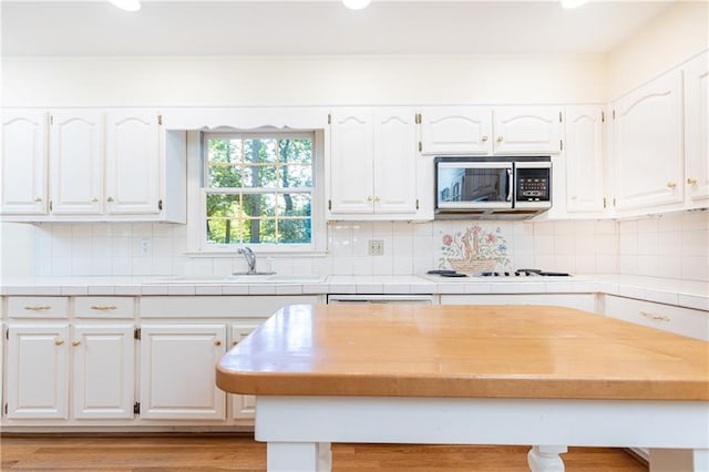 5287 Vernon Lake Dr, Atlanta, GA 30338 - kitchen with stainless steel microwave, a sink, white cabinetry, white stovetop, and recessed lighting