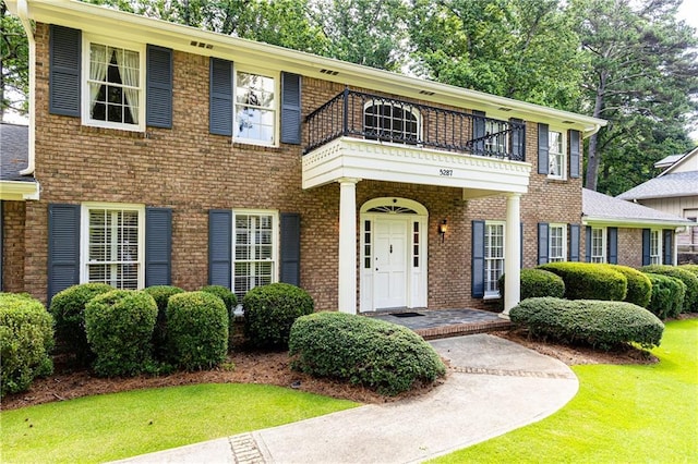 5287 Vernon Lake Dr, Atlanta, GA 30338 - view of front of home with a balcony, a front yard, and brick siding