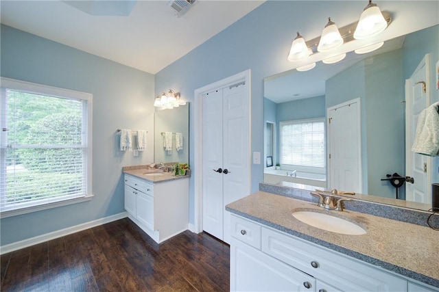 4645 Waterford Dr, Suwanee, GA 30024 - bathroom with wood finished floors, baseboards, two vanities, and a closet