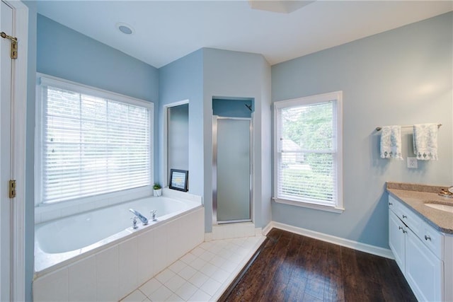 4645 Waterford Dr, Suwanee, GA 30024 - bathroom featuring vanity, a shower stall, a garden tub, baseboards, and wood finished floors