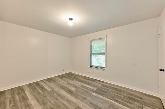 empty room featuring baseboards and wood finished floors