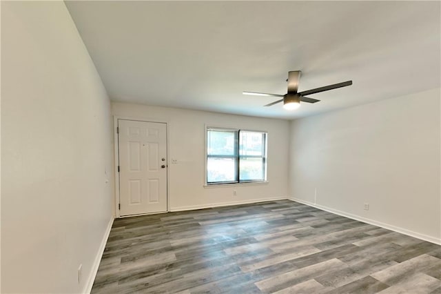 spare room featuring a ceiling fan, baseboards, and wood finished floors