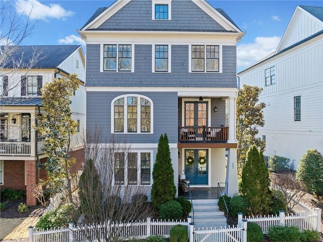 view of front of property featuring french doors, a fenced front yard, a gate, and a balcony