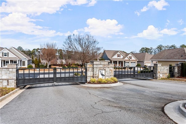 view of street featuring a residential view, a gate, and a gated entry